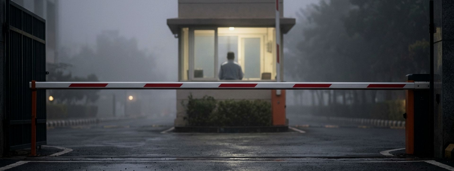 Boom barrier and guard cabin at a campus entrance in morning mist